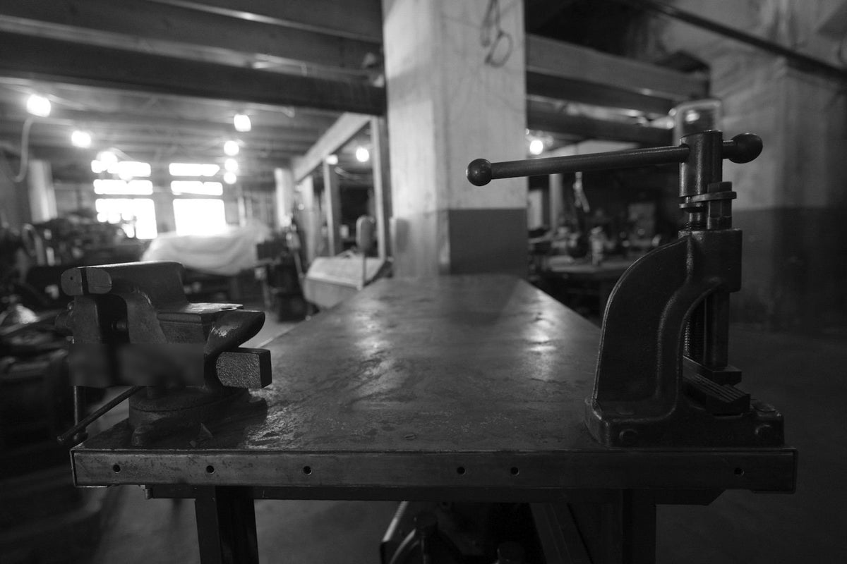 Mesa de trabajo metálica con prensa en un taller