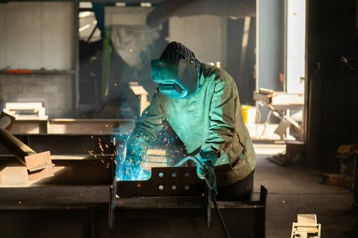 Soldador fabricando una estructura metálica en taller